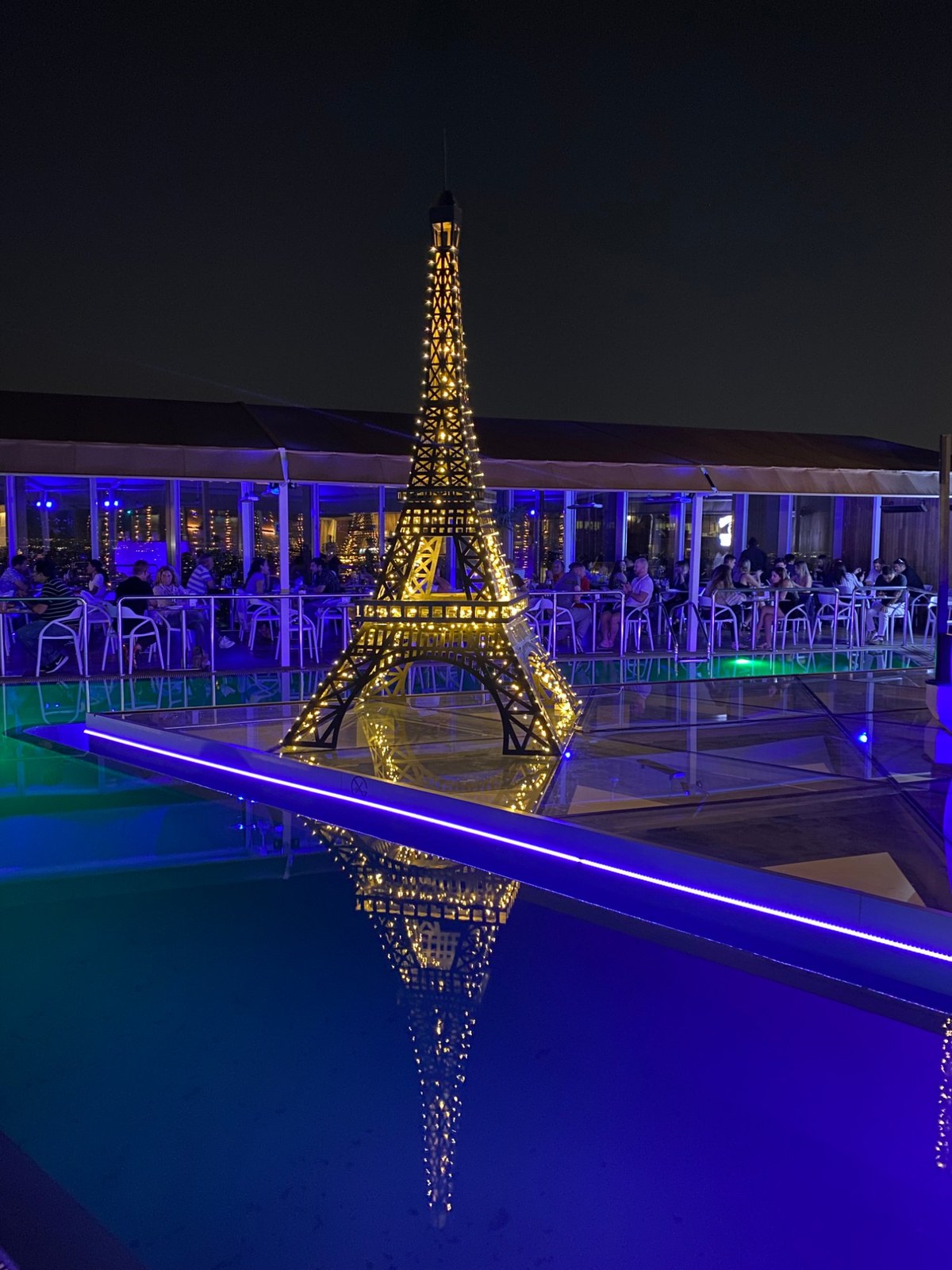 Torre Eiffel iluminada en piscina nocturna